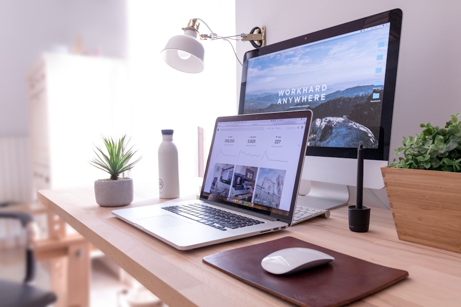 Desk with a laptop and monitor showing a website