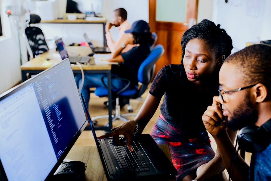 Two engineers reviewing work together on a screen